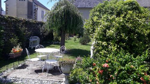 a patio with a table and chairs in a garden at l appart in Igon