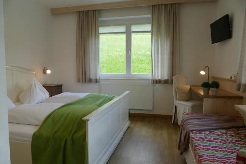 Oberwölz StadtにあるPension Geissler-Reicherのベッドと窓が備わるホテルルーム