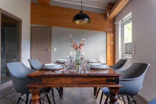 Un comedor con mesa y sillas de madera. en Velo & Wohnen -NEU- Elektroräder inklusive - Sauna, en Traben-Trarbach