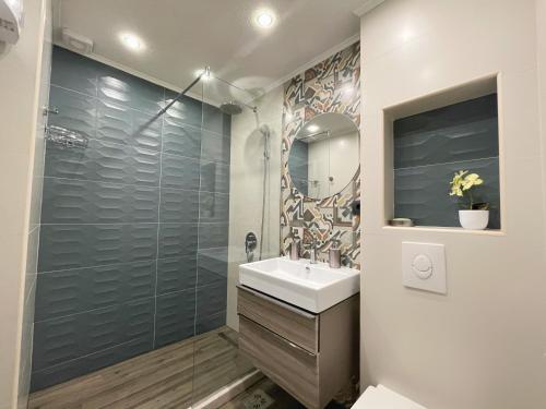een badkamer met een wastafel en een glazen douche bij Studio Apartment Irena in Sutomore