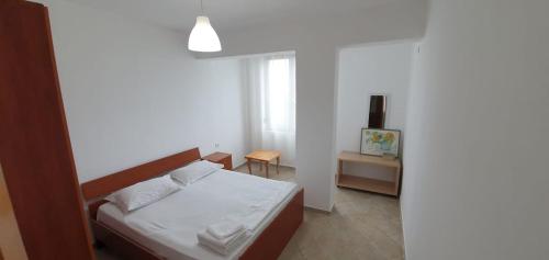 a small bedroom with a bed and a table at Seaview apartment in Borsh