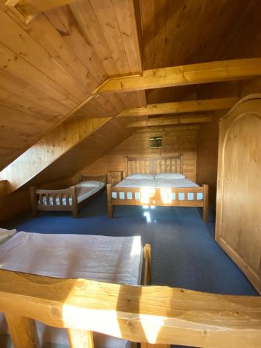 a room with two beds in a wooden cabin at Sruby Haida in Ceske Petrovice