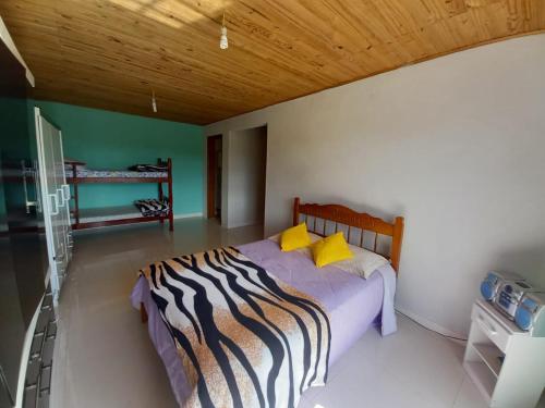 1 dormitorio con 1 cama con almohadas amarillas en marias, en Campos do Jordão