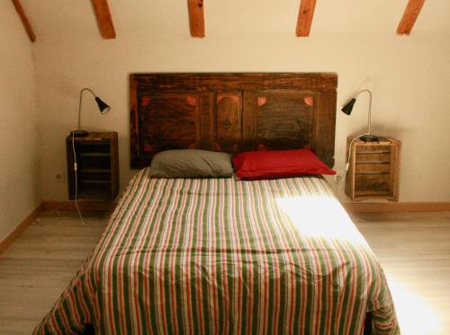 um quarto com uma cama grande e uma cabeceira em madeira em grande Cahute em Soultzmatt