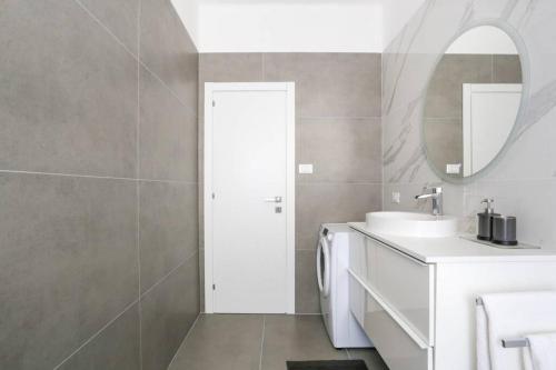 een witte badkamer met een wastafel en een spiegel bij Tommy's Flat in Mestre