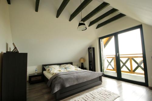 a bedroom with a bed and a large window at Bajkowy domek in Lubin