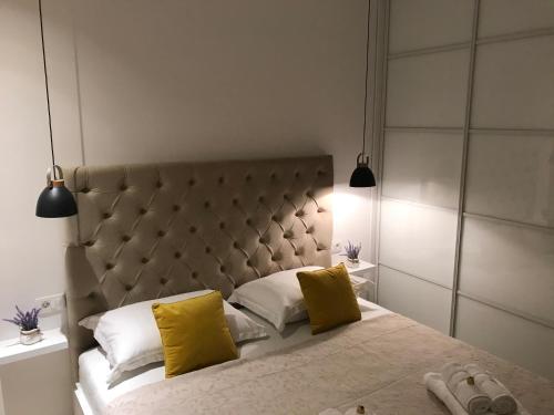 a bedroom with a large bed with two yellow pillows at Central Park Residence in Split
