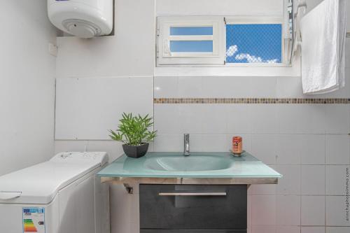 Elle comprend une petite cuisine avec un évier et une fenêtre. dans l'établissement Agréable Séjour, à Sainte-Luce