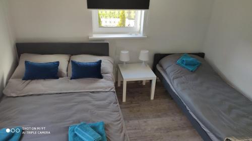 a bedroom with two beds and a table with a window at Pike Fishing Camp in Nadole
