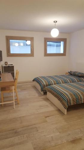 1 dormitorio con 2 camas, mesa y escritorio en Casa Monstagol, en Soiano del Lago