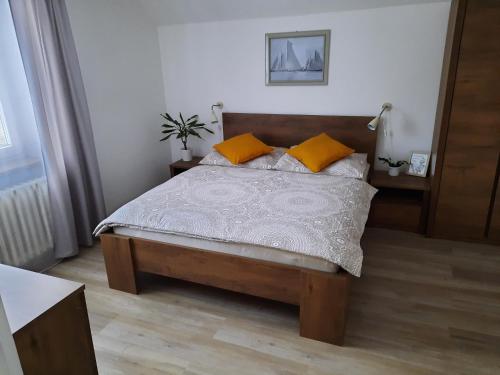 een slaapkamer met een bed met 2 oranje kussens bij Penzion U zlaté collie in Doksy