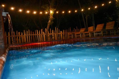 a swimming pool at night with a fence and lights at Finca Avellanas in Playa Avellana