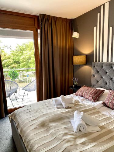 a bedroom with a large bed with towels on it at Veja's apartmani in Krk