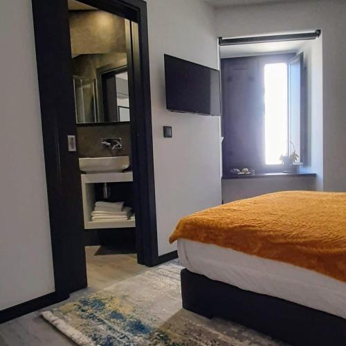 a bedroom with a bed and a mirror and a window at Taska Vila Velha in Mirandela