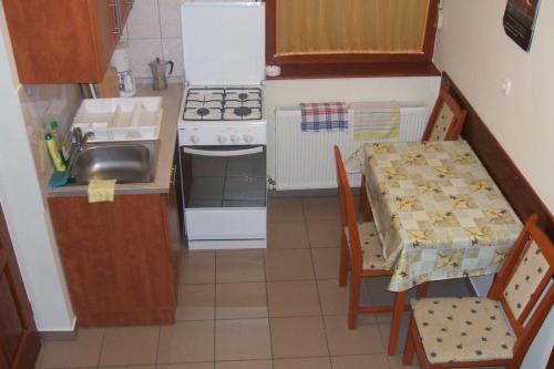 een kleine keuken met een tafel en een wastafel bij Kertész Vendégház in Hegykő