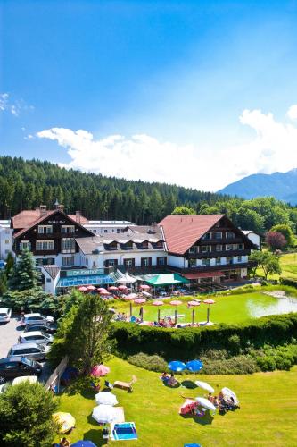 a resort with a bunch of people laying on the grass at Hotel Gruberhof Innsbruck Igls B&B in Innsbruck