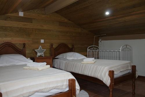 two beds in a room with wooden walls at COZY HOUSE in Fão