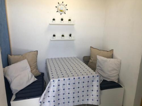 a table and two chairs in a room with a clock at Pia Beach House in Bacoli
