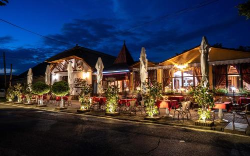 een restaurant met 's avonds tafels en stoelen bij Penzión Heléné in Veľký Meder