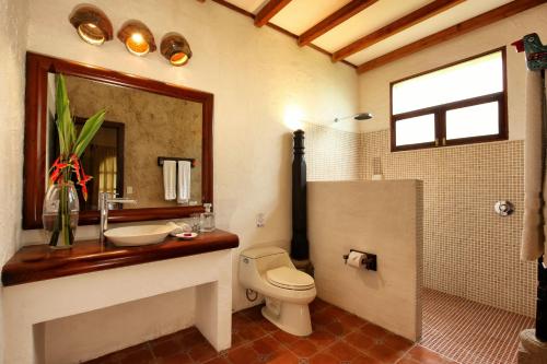 a bathroom with a toilet and a sink and a mirror at Villa Santa Catarina in Panajachel