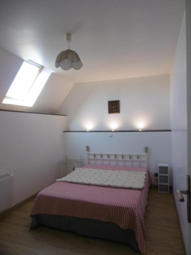 a bedroom with a bed with a pink blanket at Les Mouettes in Plouër-sur-Rance