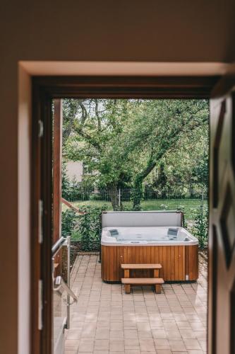 a room with a hot tub and a bench on a patio at Villa Tília Balatongyörök in Balatongyörök