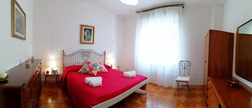 um quarto com uma cama vermelha e uma janela em La Lantana Taormina em Taormina