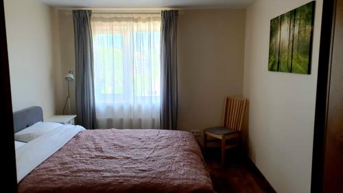 ein kleines Schlafzimmer mit einem Bett und einem Fenster in der Unterkunft KANTO - self check in in Klaipėda