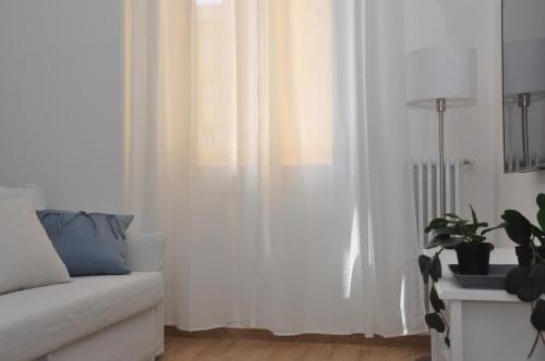 a living room with a white curtain and a couch at Verdi Due in Modena