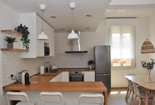 a kitchen with a stainless steel refrigerator and a table at Verdi Due in Modena