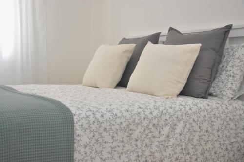 a bed with gray and white pillows on it at Verdi Due in Modena