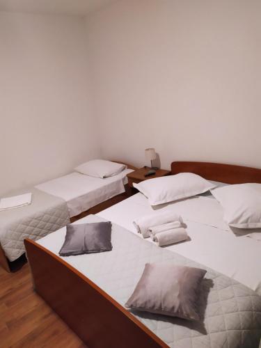 two beds in a room with white sheets and pillows at Krka Ivan in Lozovac