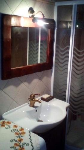 a bathroom with a sink and a mirror at La Casa di Pietra in Karpenision