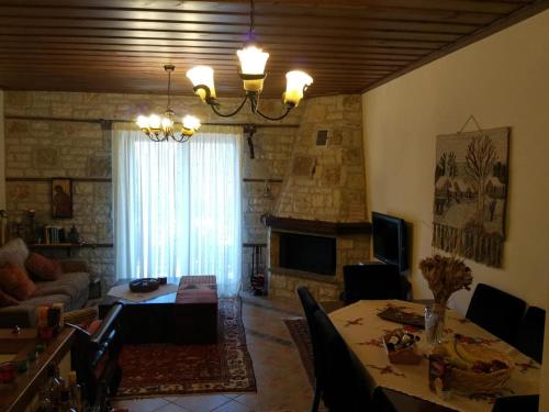 ein Wohnzimmer mit einem Tisch und einem Kamin in der Unterkunft La Casa di Pietra in Karpenisi