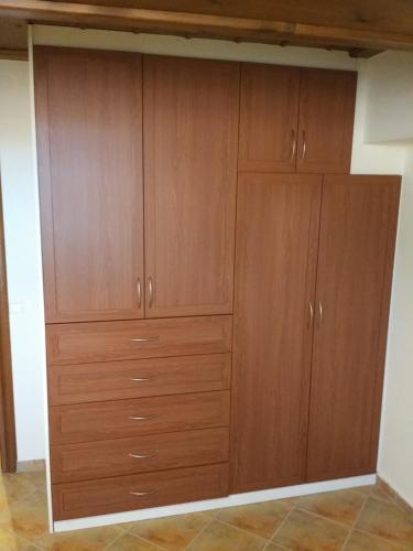 a large closet with wooden cabinets in a room at La Casa di Pietra in Karpenision