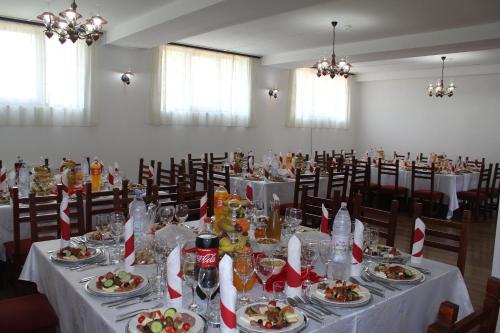 ein Esszimmer mit einem Tisch und Teller mit Lebensmitteln in der Unterkunft Perla Muresului in Alba Iulia