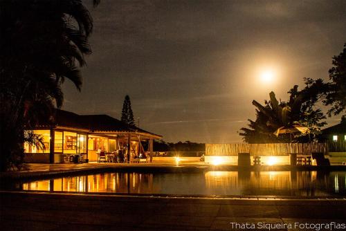 a night view of a house with lights on the water at The Eco Palace Hostel in Búzios