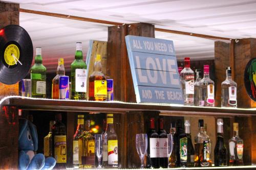 a bar with a lot of bottles of alcohol at The Eco Palace Hostel in Búzios