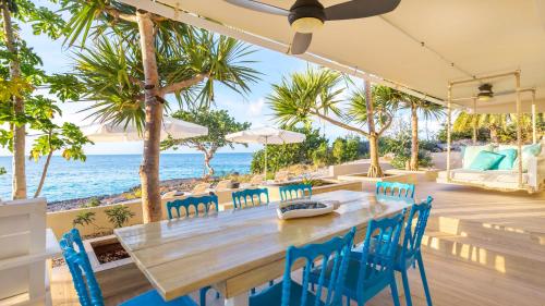 a dining room with a table and chairs and the ocean at Sandcastle Villa in Crocus Hill