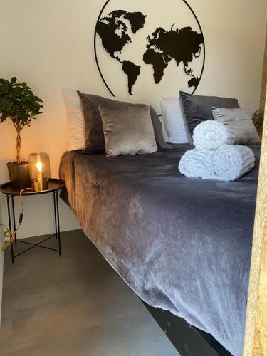 a bedroom with a large bed with a globe on the wall at Slapen bij van O 1 in Yerseke