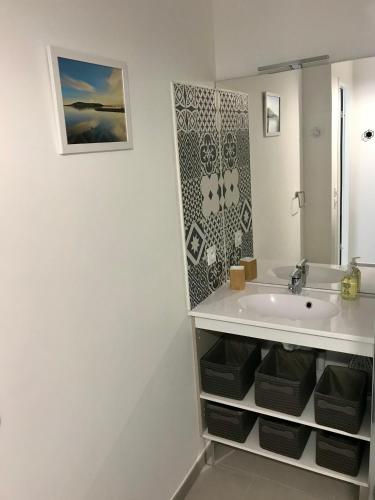 une salle de bain blanche avec un lavabo et un miroir dans l'établissement BLUE NOTE -4 étoiles-Terrasse Vue-2 Parking, à Balaruc-les-Bains