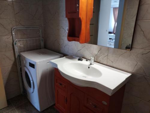 a bathroom with a sink and a washing machine at Mona in Mamaia
