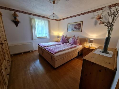 ein Schlafzimmer mit einem Bett mit lila Kissen darauf in der Unterkunft Camping Gasthof Zirknitzer in Großkirchheim