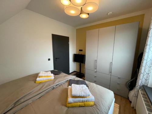 a bedroom with a bed with towels on it at Ferienhaus Kompass (ehemals Pension Hohlen) in Carolinensiel