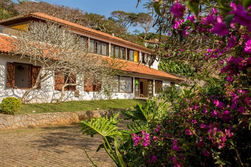 a house with pink flowers in front of it at The Eco Palace Hostel in Búzios