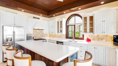 a kitchen with white cabinets and a large white island at Sandcastle Villa in Crocus Hill