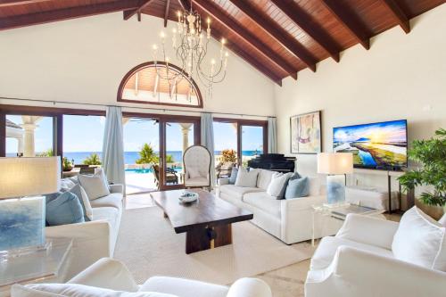 a living room with white furniture and a chandelier at Sandcastle Villa in Crocus Hill