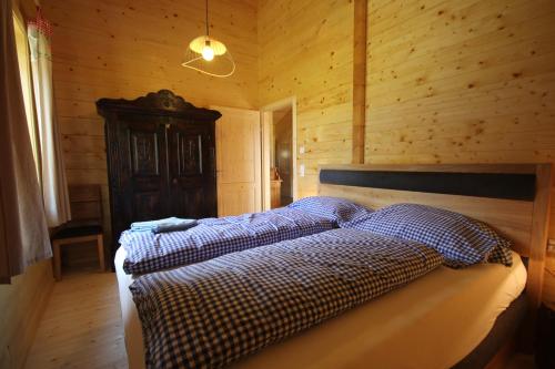 a bedroom with a bed in a wooden room at Chalet Stressless in Presseggen