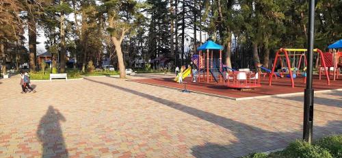 a shadow of a person standing next to a playground at Кобулети резиденс двухспални Апартамент Андри in K'obulet'i
