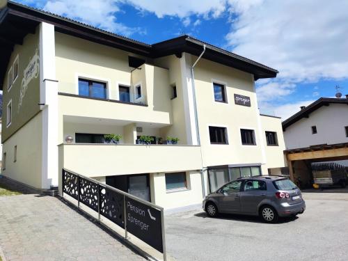 a building with a car parked in front of it at Pension Sprenger in San Valentino alla Muta